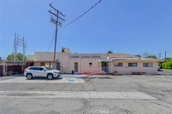 a front view of a house with cars parked