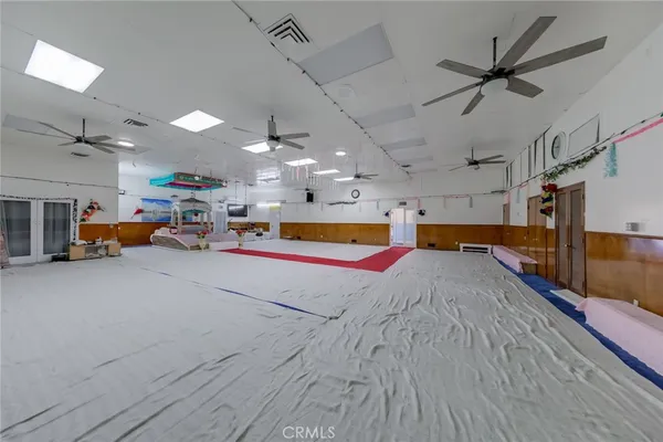 a room with lots of white furniture and a chandelier