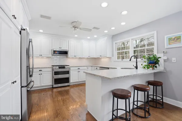 a kitchen with stainless steel appliances granite countertop a stove refrigerator sink and cabinets