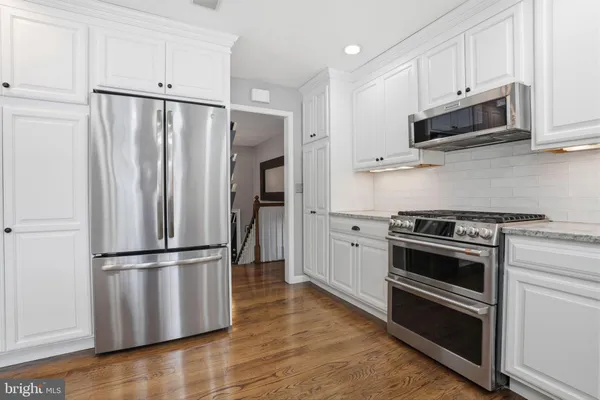 a kitchen with stainless steel appliances and granite countertop wooden cabinets