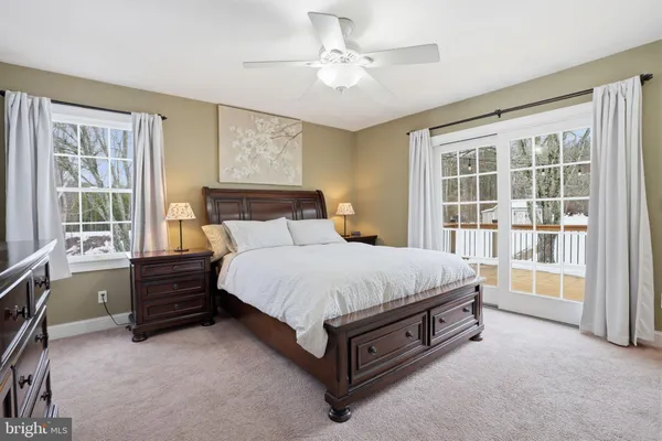 a bed sitting in a spacious bedroom next to a window