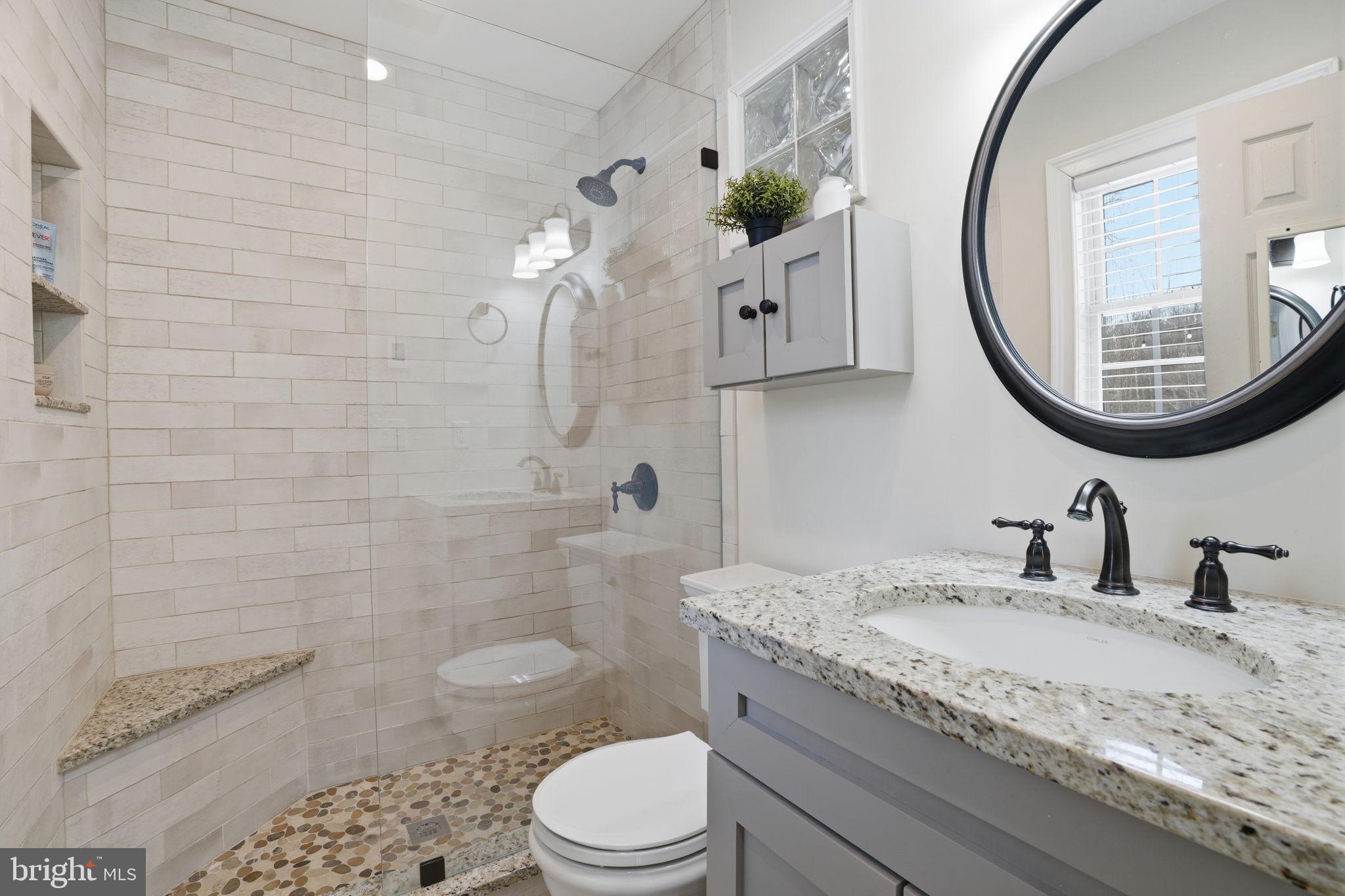 521 Cokesbury Road Annandale, NJ 08801 - Photo 23 of 56 a bathroom with a granite countertop toilet a sink a mirror and a shower
