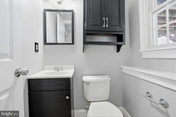 a bathroom with a toilet a sink and mirror