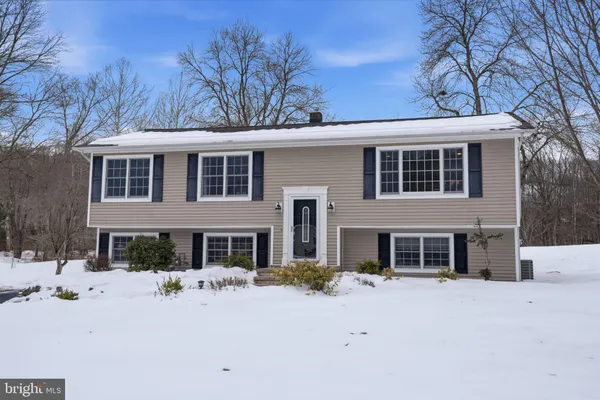 a front view of a house with a yard covered in snow