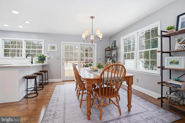 a dining room with furniture a chandelier and wooden floor