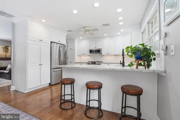 a kitchen with stainless steel appliances granite countertop a counter top space cabinets and wooden floor