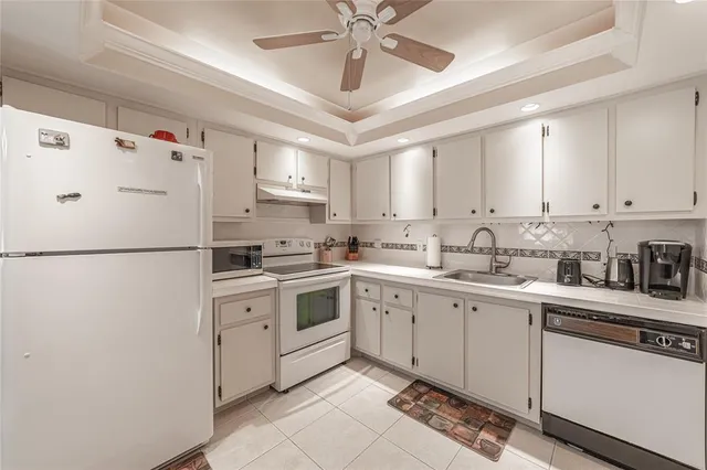a kitchen with cabinets a sink and white stainless steel appliances