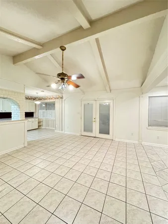 a view of an empty room with a chandelier fan