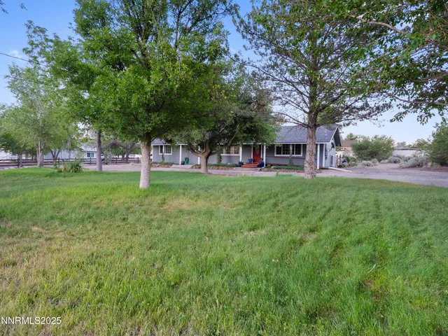a view of a house with a big yard and large trees