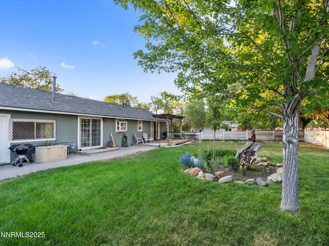 an aerial view of a house with a yard and trees all around