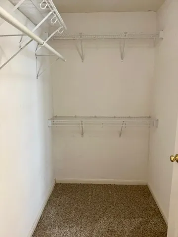 an empty room with a chandelier fan and windows