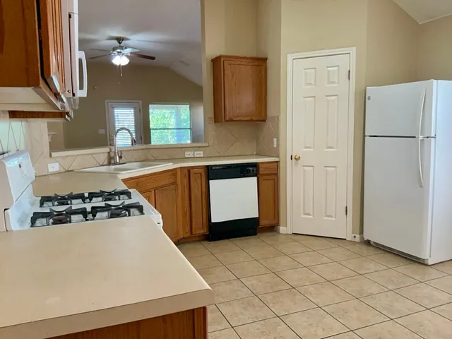 a kitchen with a stove a refrigerator and a sink
