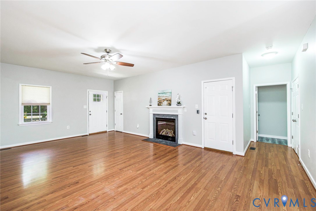 1297 Manfield Road Aylett, VA 23009 - Photo 15 of 41 an empty room with a fireplace and wooden floor