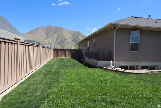 1055 North 1000 East Mapleton, UT 84664 - Photo 81 of 112 Expansive backyard featuring a manicured lawn, a full privacy fence, and a stucco exterior