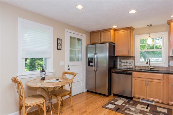 104 Roy Street Springfield, MA 01104 - Photo 12 of 30 a kitchen with stainless steel appliances granite countertop a refrigerator a sink a stove a dining table and chairs