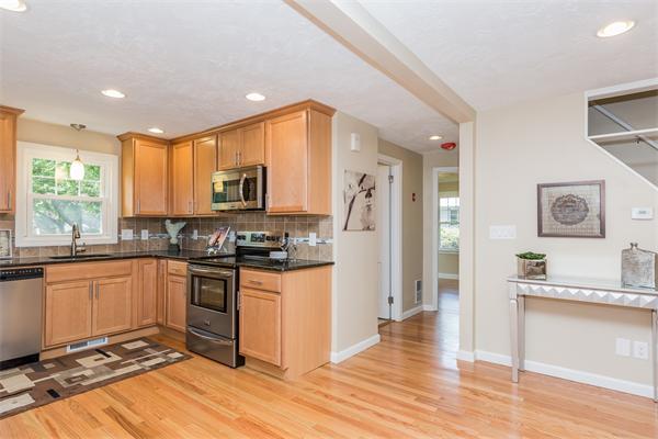 104 Roy Street Springfield, MA 01104 - Photo 15 of 30 a kitchen with stainless steel appliances granite countertop a stove top oven a sink dishwasher and a refrigerator with wooden floor
