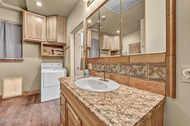 a bathroom with a granite countertop sink a mirror and shower