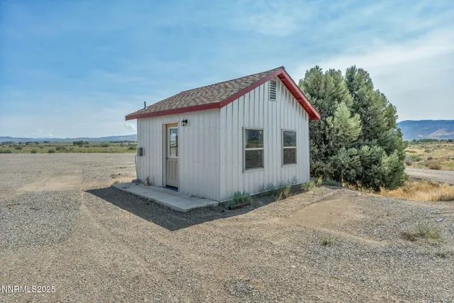 a view of a small house with wooden fence