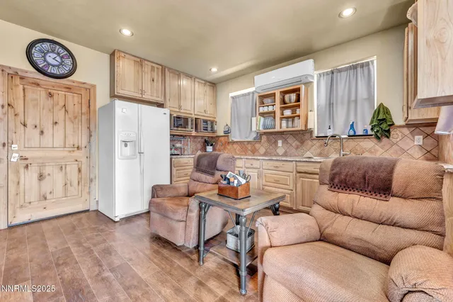 a living room with furniture a large window and stainless steel appliances