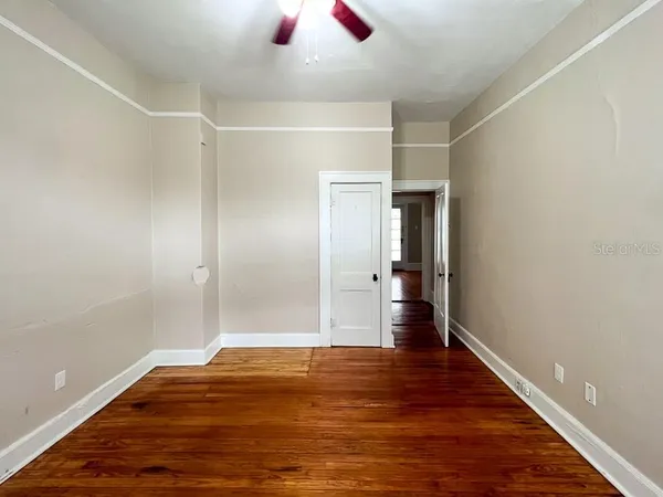 a view of empty room with wooden floor