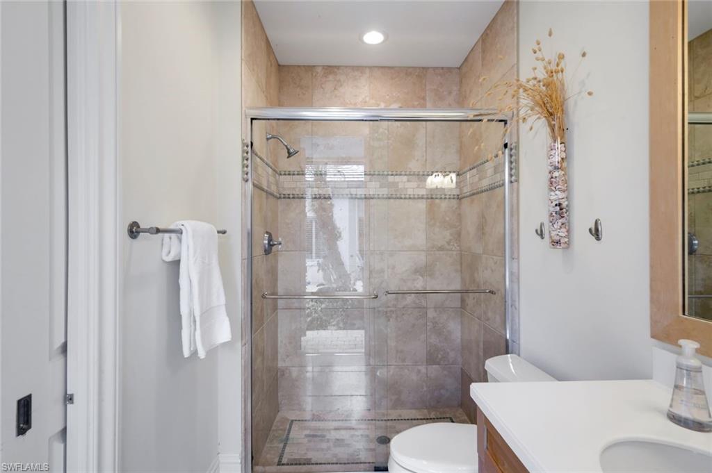 1284 Pocantico Lane Naples, FL 34110 - Photo 44 of 50 Cabana En-Suite Bath w. French Door to Lanai; Wall-to-Ceiling Stone Tile w. Designer Detail
