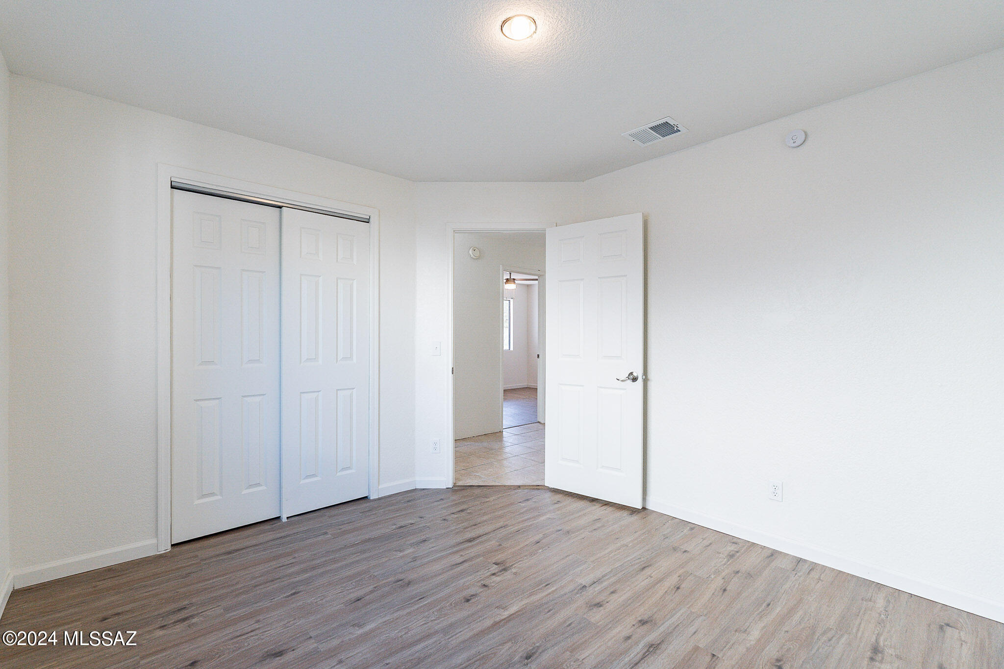 2690 West Sunset Road Tucson, AZ 85741 - Photo 21 of 33 a view of an empty room with wooden floor and closet