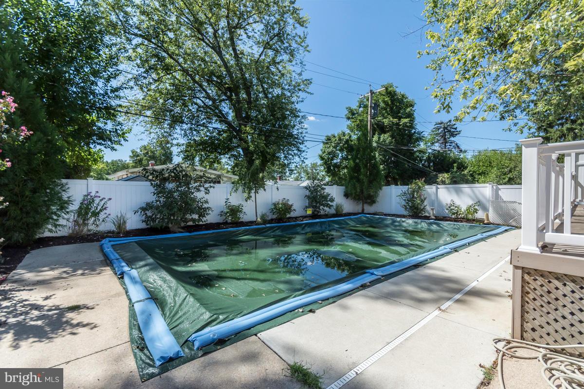 4757 Bonnie Brae Road Pikesville, MD 21208 - Photo 26 of 30 a view of a backyard with lawn chairs under an umbrella