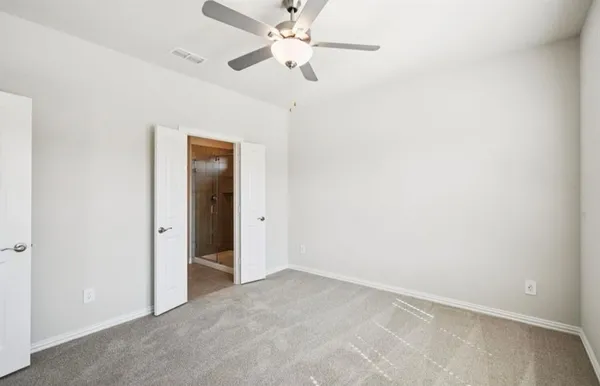 an empty room with closet and a chandelier fan
