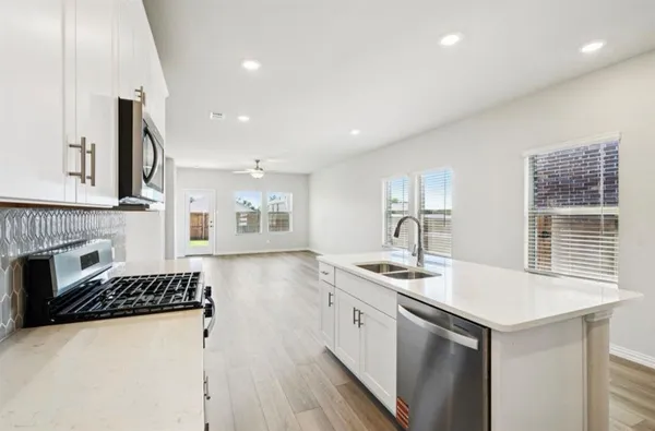 a kitchen with sink a stove and cabinets