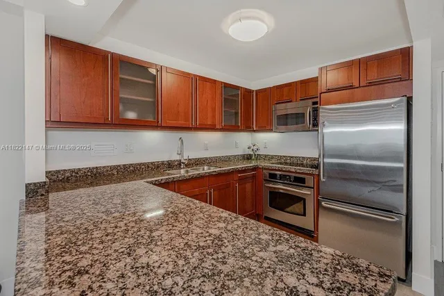 a kitchen with granite countertop stainless steel appliances and wooden cabinets