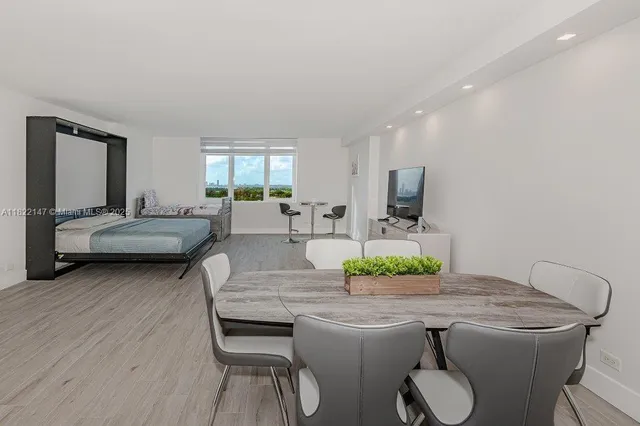 a living room with a bed furniture and a potted plant