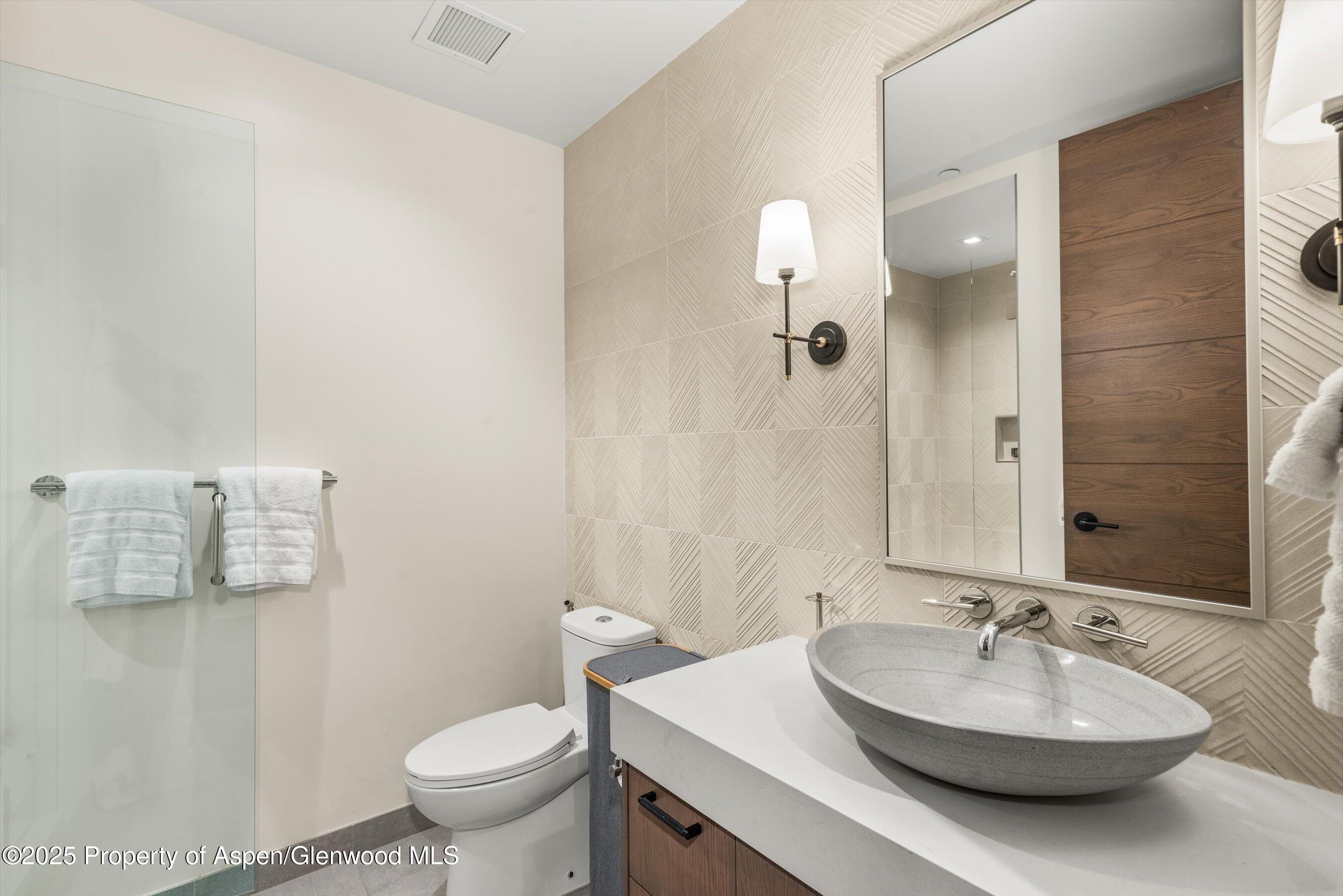 180 Wood Road, Unit 404 Snowmass Village, CO 81615 - Photo 14 of 51 a bathroom with a sink a toilet and a mirror