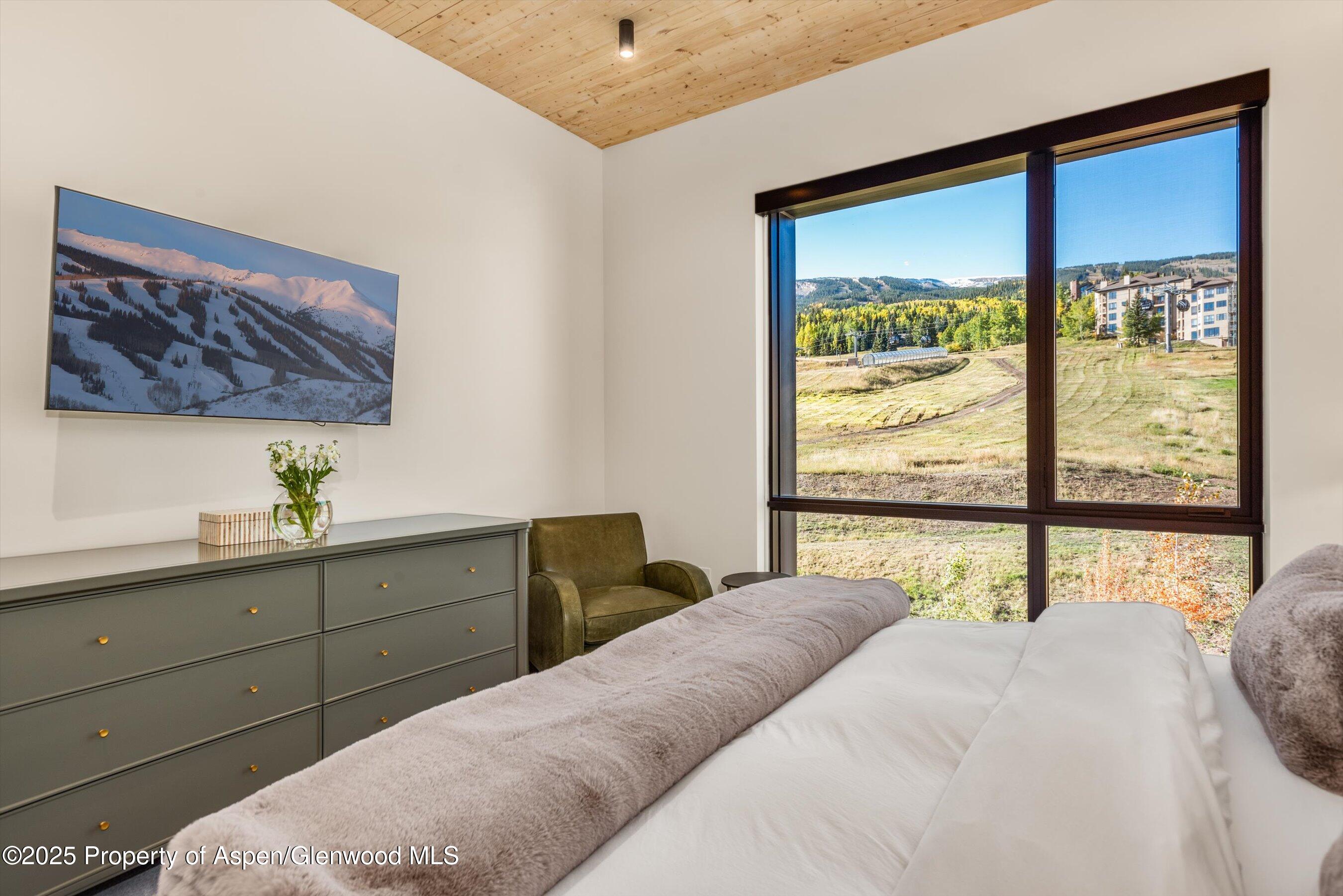 180 Wood Road, Unit 404 Snowmass Village, CO 81615 - Photo 6 of 51 a bedroom with a large bed and a window