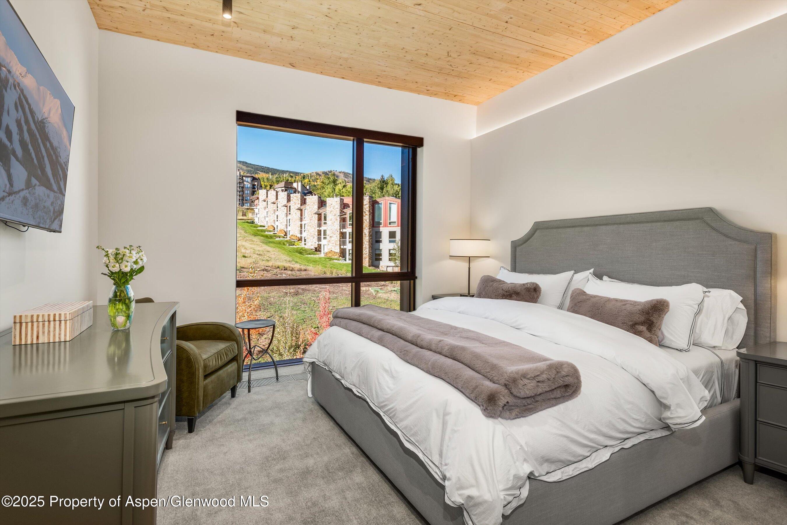 180 Wood Road, Unit 404 Snowmass Village, CO 81615 - Photo 7 of 51 a bedroom with a bed and a couch