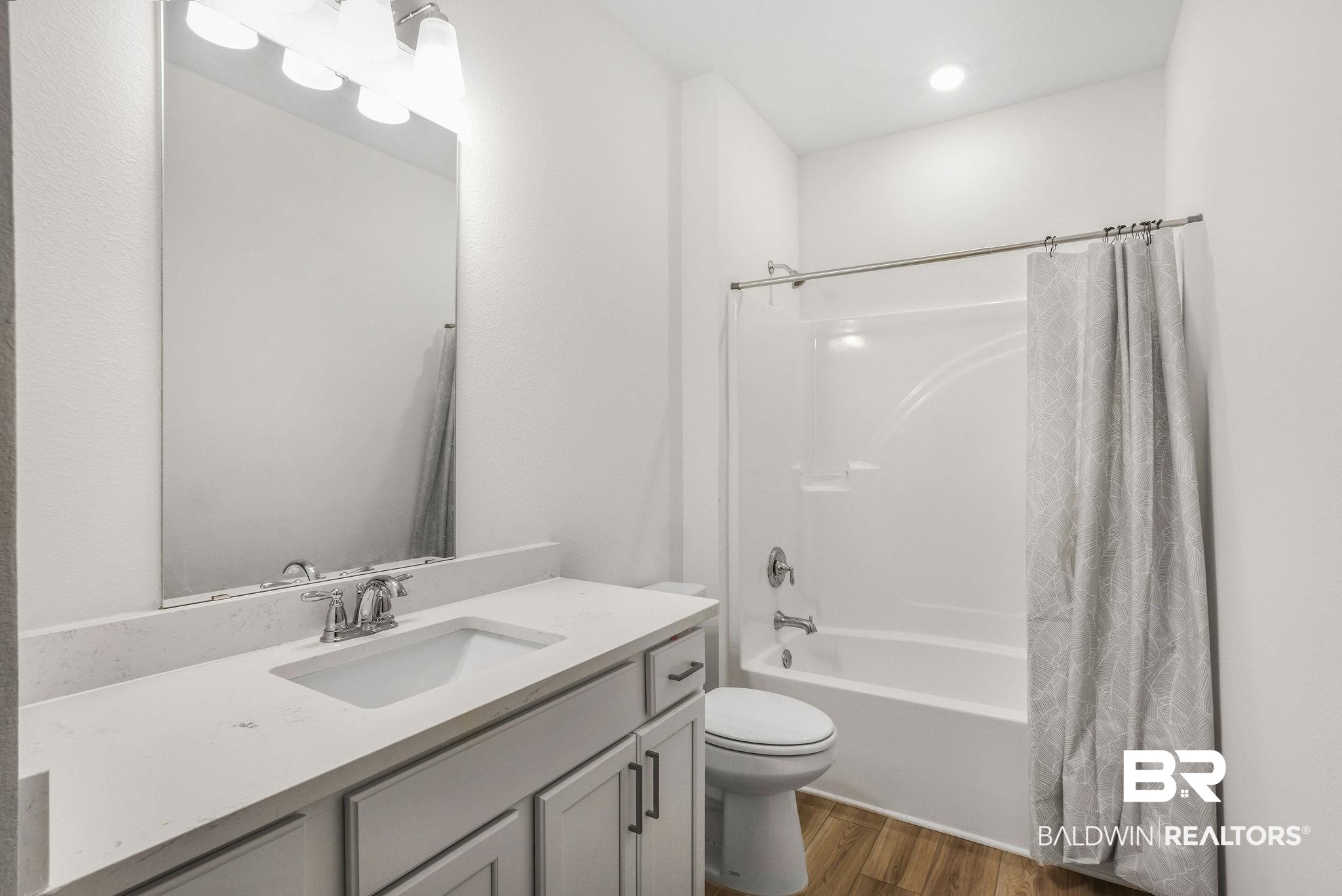 9859 Willet Way Foley, AL 36535 - Photo 20 of 23 Bathroom featuring shower / bathtub combination with curtain, vanity, dark wood-style flooring, and recessed lighting