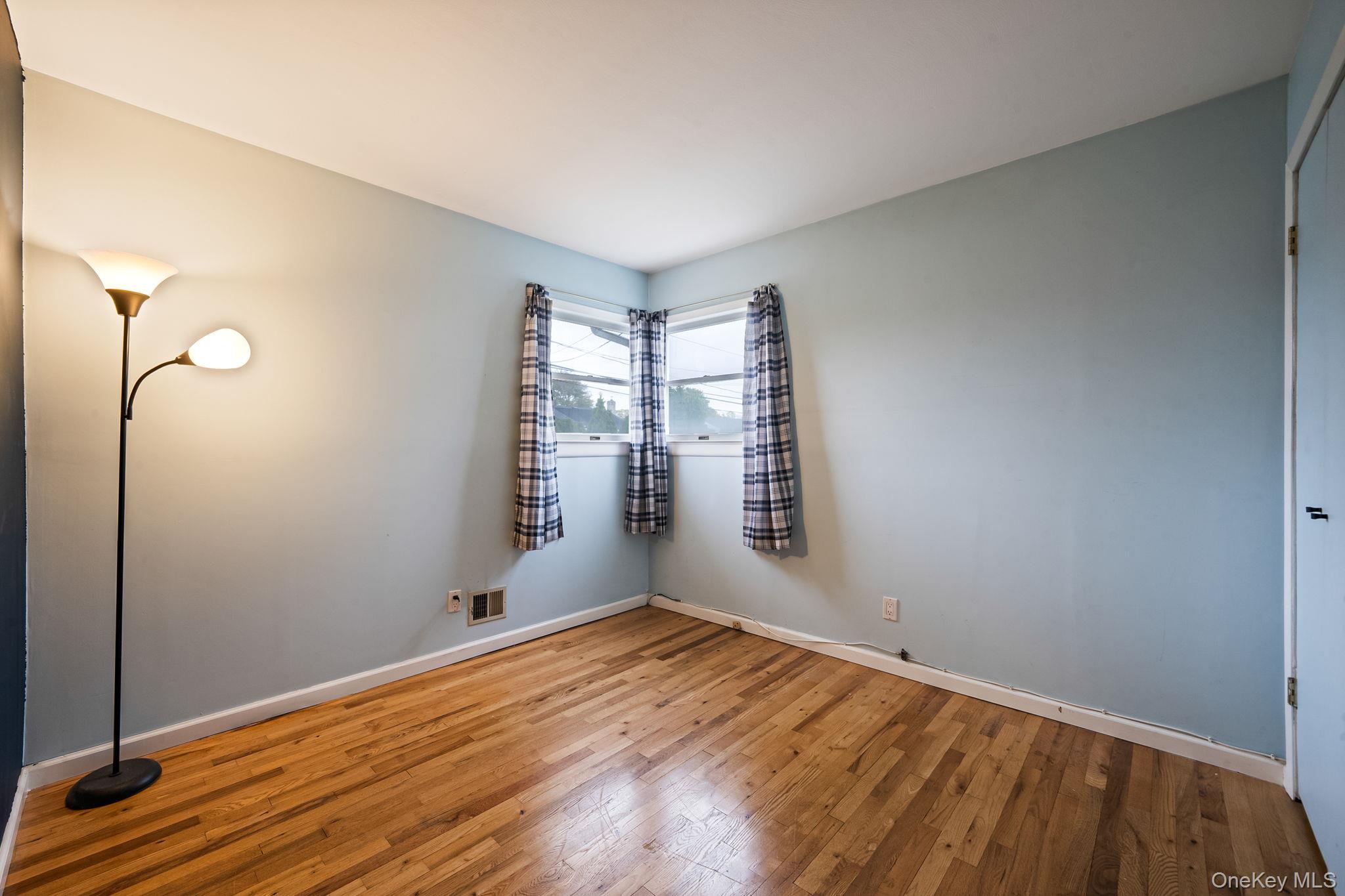 29 Franklin Street Islip, NY 11751 - Photo 21 of 39 a view of empty room with wooden floor and fan