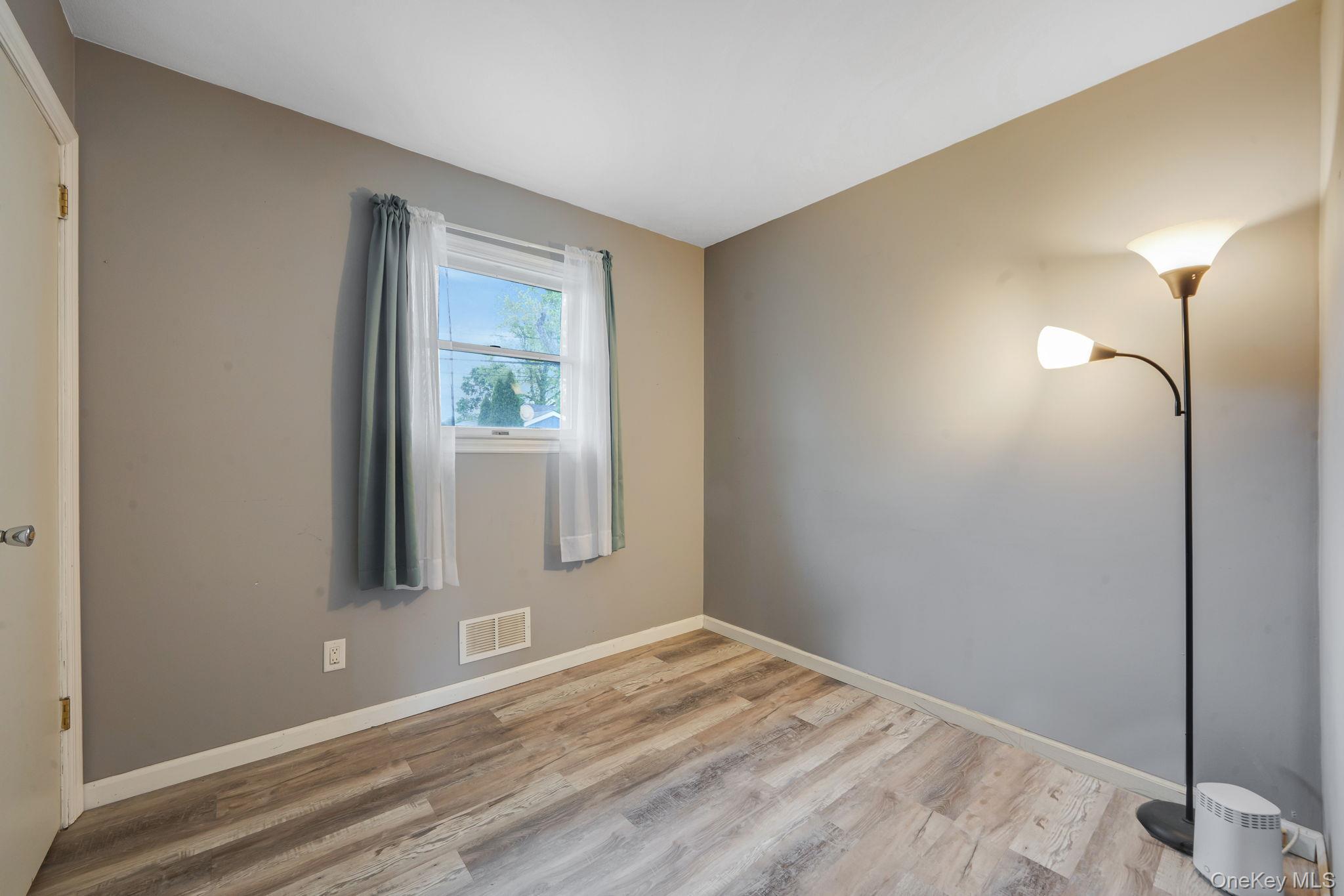 29 Franklin Street Islip, NY 11751 - Photo 23 of 39 a view of an empty room with wooden floor and a window