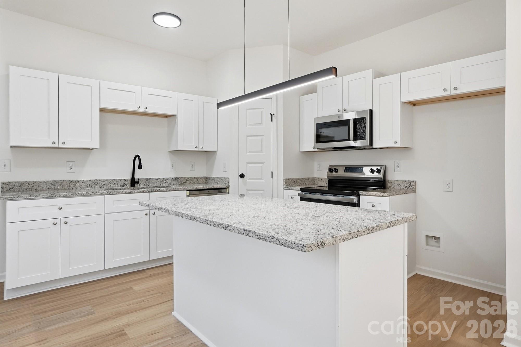 711 Adams Street Monroe, NC 28110 - Photo 11 of 25 a kitchen with stainless steel appliances granite countertop a sink a stove a microwave and cabinets