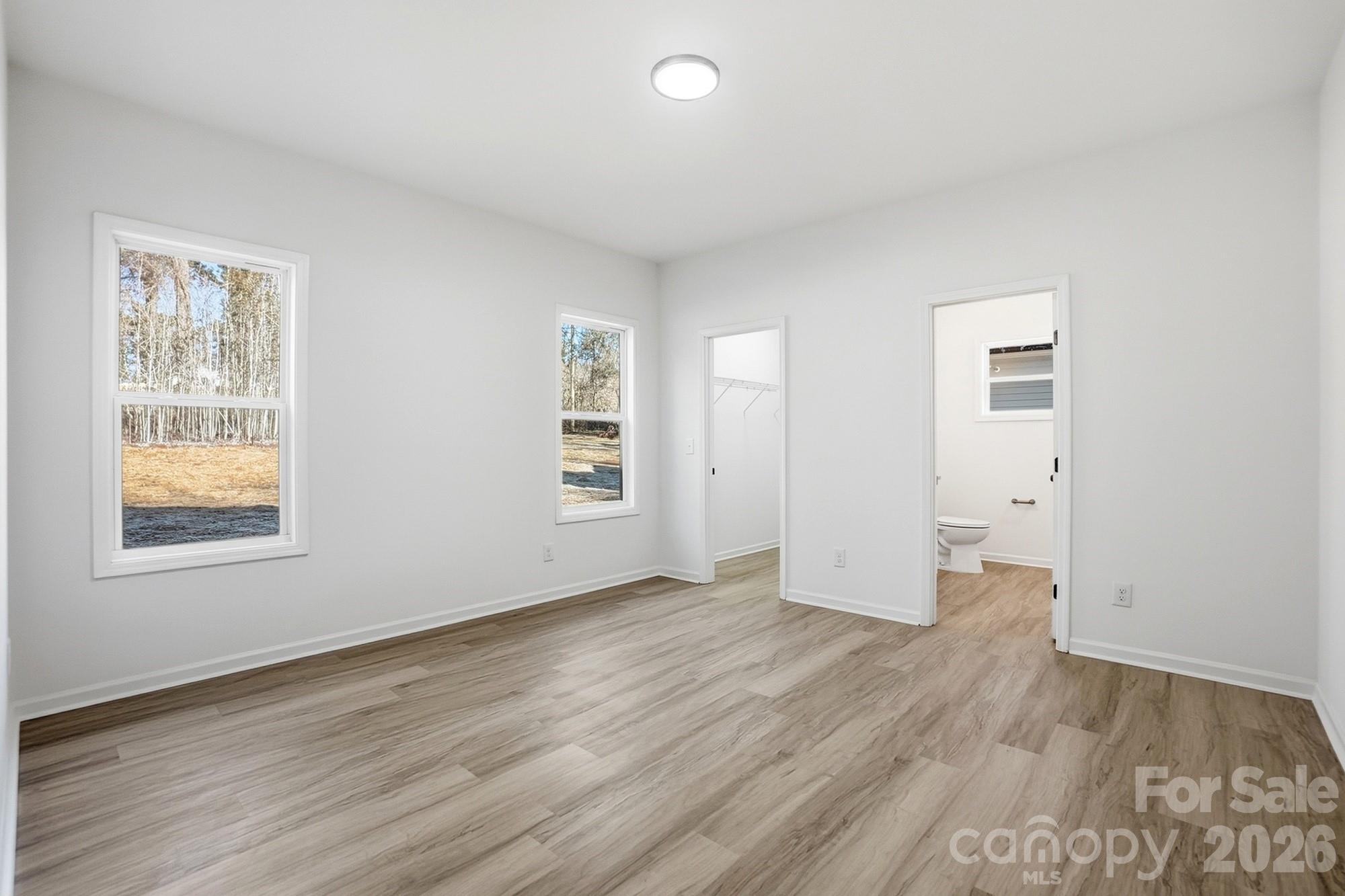 711 Adams Street Monroe, NC 28110 - Photo 16 of 25 an empty room with wooden floor and windows