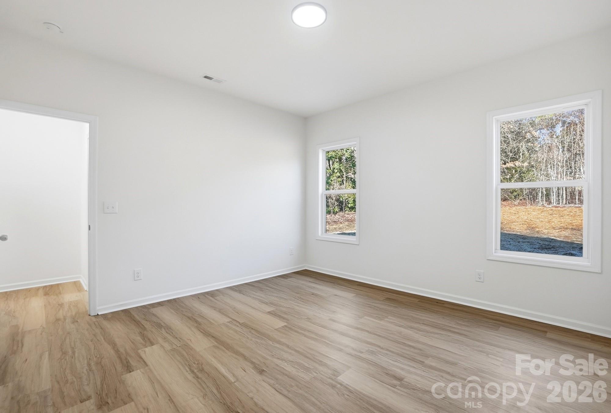 711 Adams Street Monroe, NC 28110 - Photo 17 of 25 an empty room with wooden floor and windows