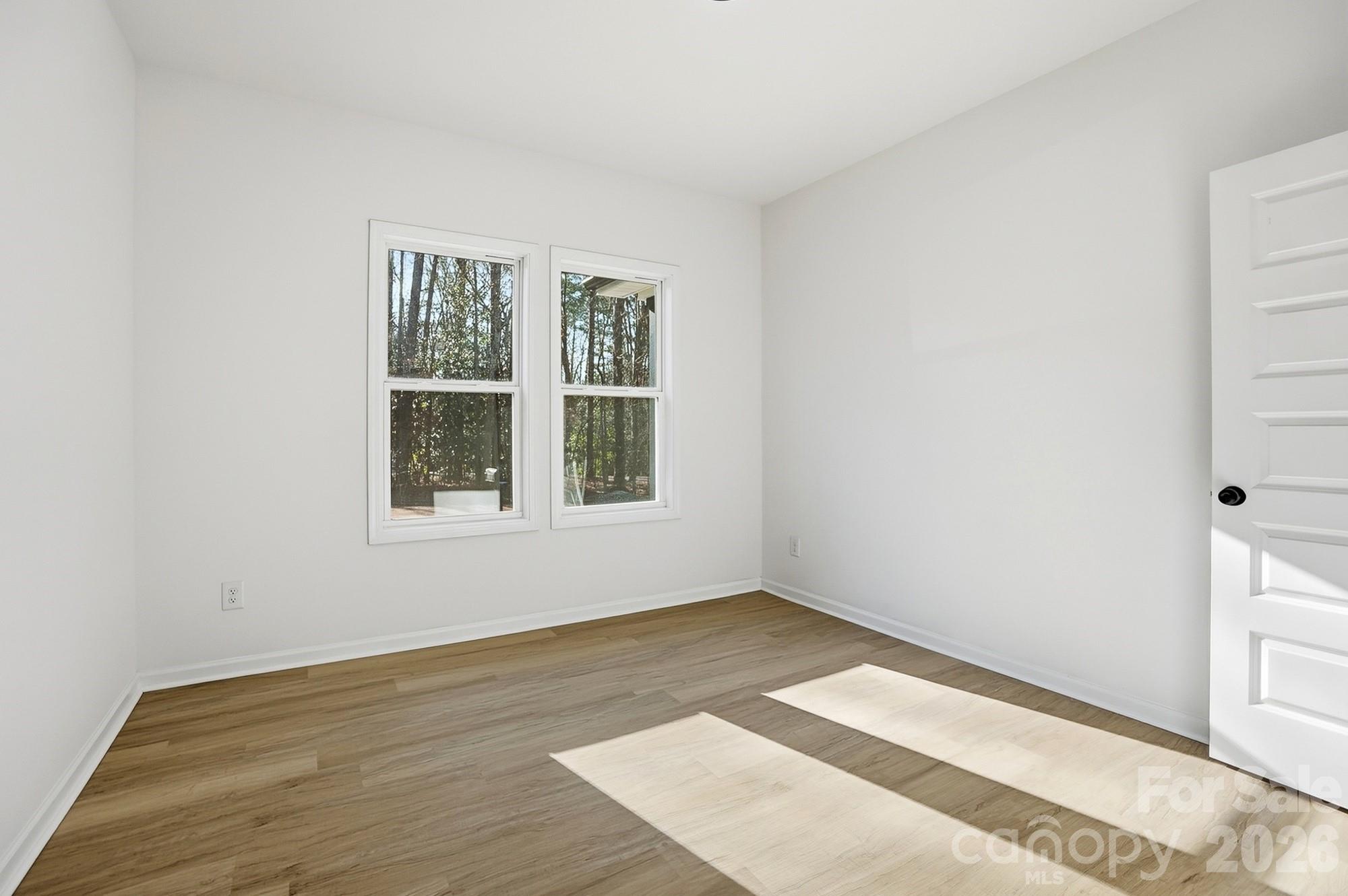711 Adams Street Monroe, NC 28110 - Photo 19 of 25 a view of an empty room with wooden floor and a window