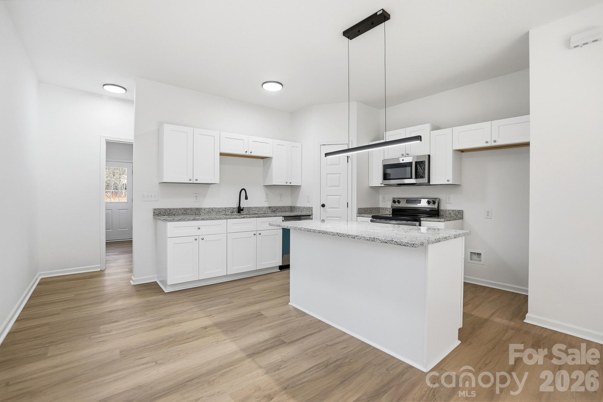711 Adams Street Monroe, NC 28110 - Photo 9 of 25 a kitchen with cabinets stainless steel appliances a sink and a counter top space