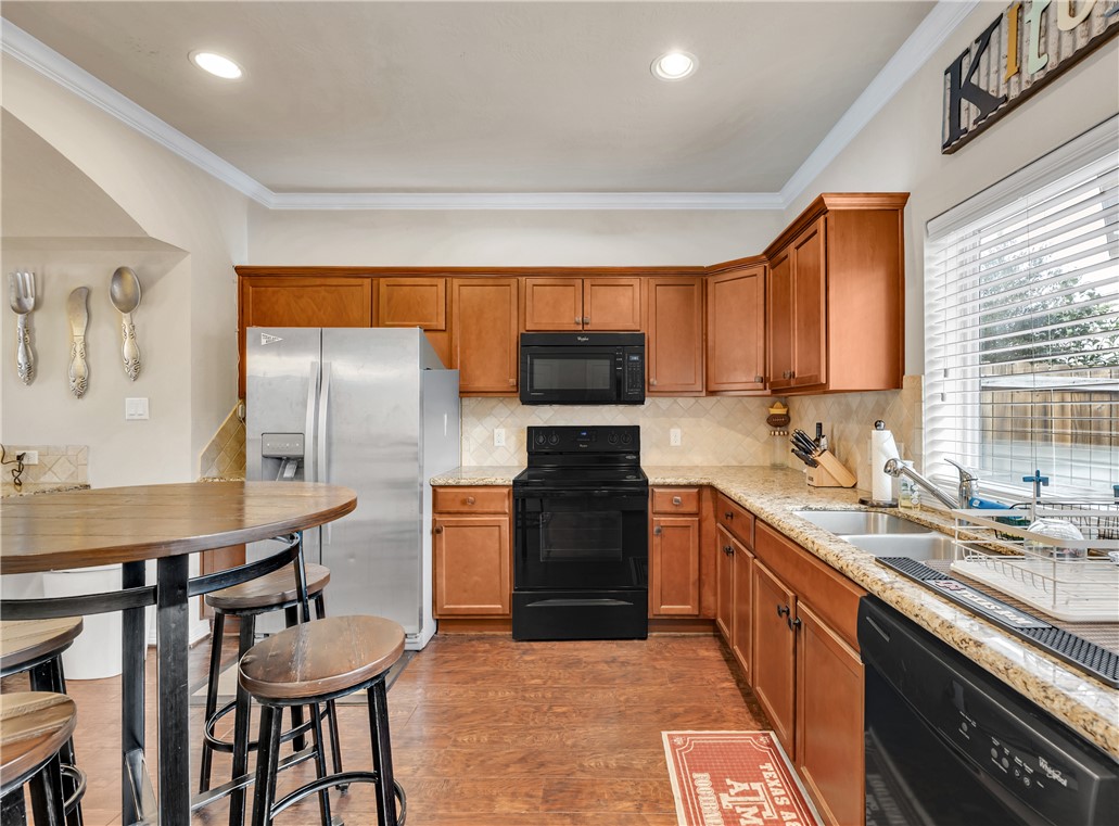 1198 Jones-Butler Road, Unit 2305 College Station, TX 77840 - Photo 7 of 25 a kitchen with stainless steel appliances granite countertop a stove a sink and a refrigerator