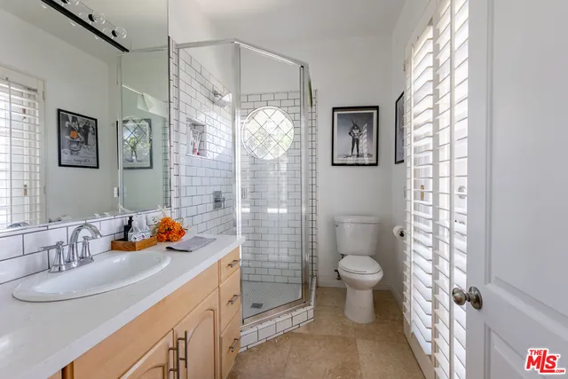 a bathroom with a sink a toilet a shower and a mirror