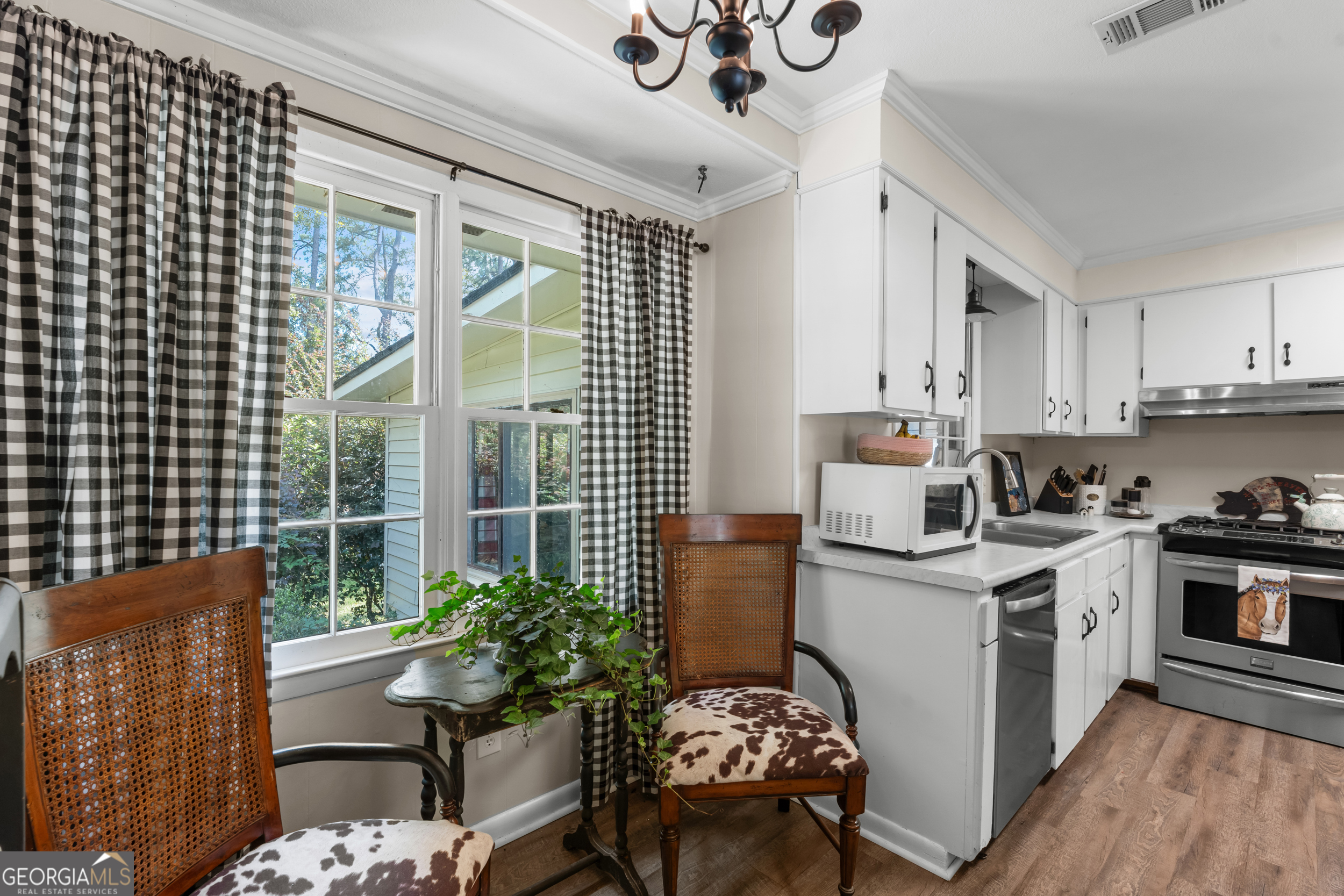 313 Gentilly Road Statesboro, GA 30458 - Photo 13 of 25 a open kitchen with stainless steel appliances granite countertop a stove a sink dishwasher a microwave oven and a dining table with wooden floor