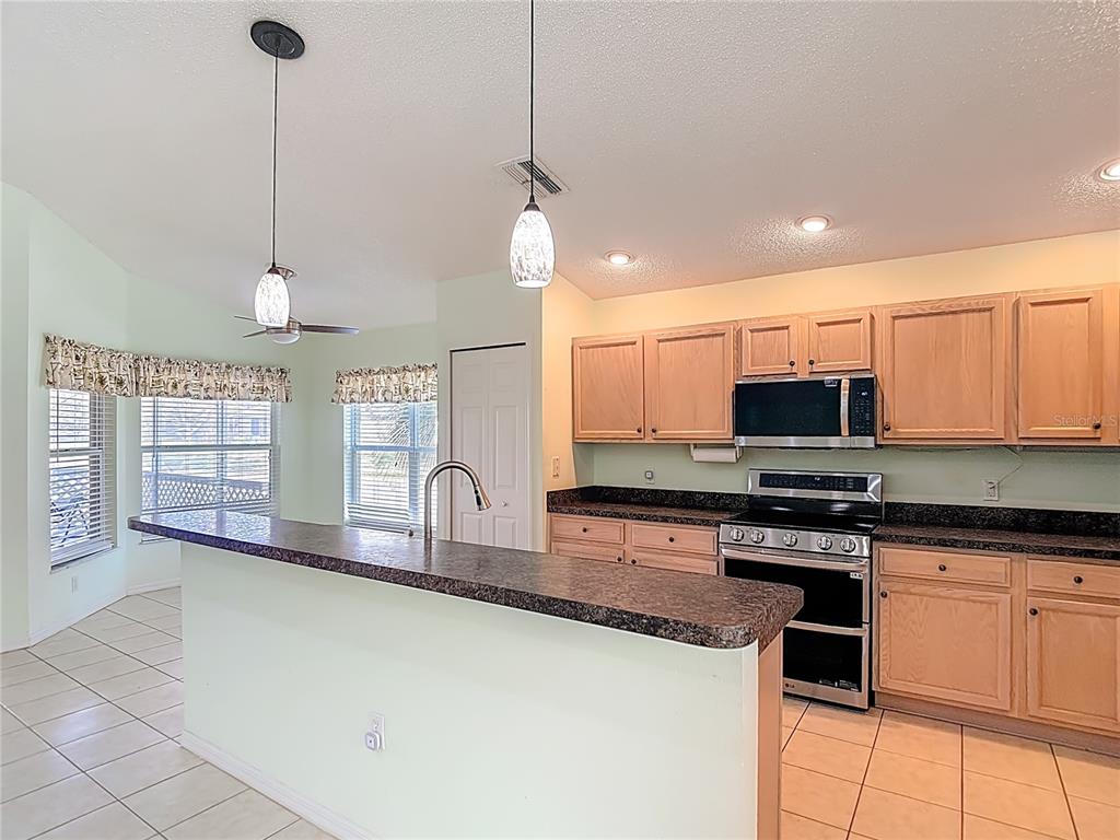 280 Quane Avenue Spring Hill, FL 34609 - Photo 15 of 62 a kitchen with stainless steel appliances granite countertop a stove a sink and a refrigerator