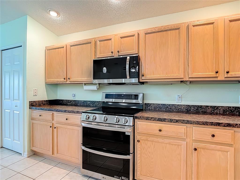 280 Quane Avenue Spring Hill, FL 34609 - Photo 16 of 62 a kitchen with granite countertop cabinets stainless steel appliances and a sink