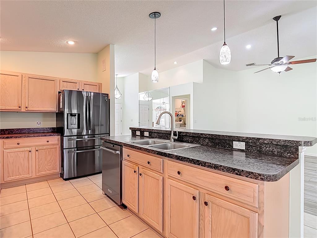 280 Quane Avenue Spring Hill, FL 34609 - Photo 19 of 62 a kitchen with stainless steel appliances granite countertop a sink a stove a refrigerator a center island and cabinets
