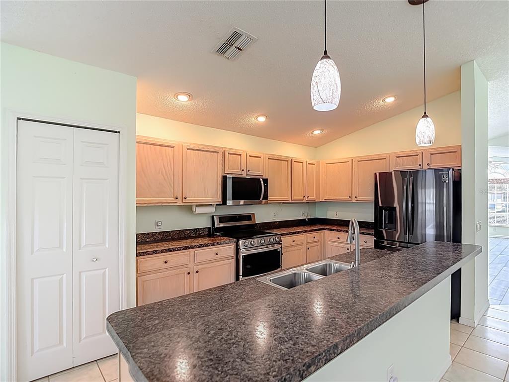 280 Quane Avenue Spring Hill, FL 34609 - Photo 21 of 62 a kitchen with stainless steel appliances granite countertop a sink a stove and a refrigerator