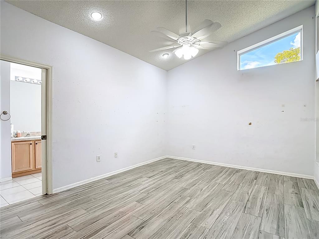 280 Quane Avenue Spring Hill, FL 34609 - Photo 26 of 62 an empty room with wooden floor chandelier and windows